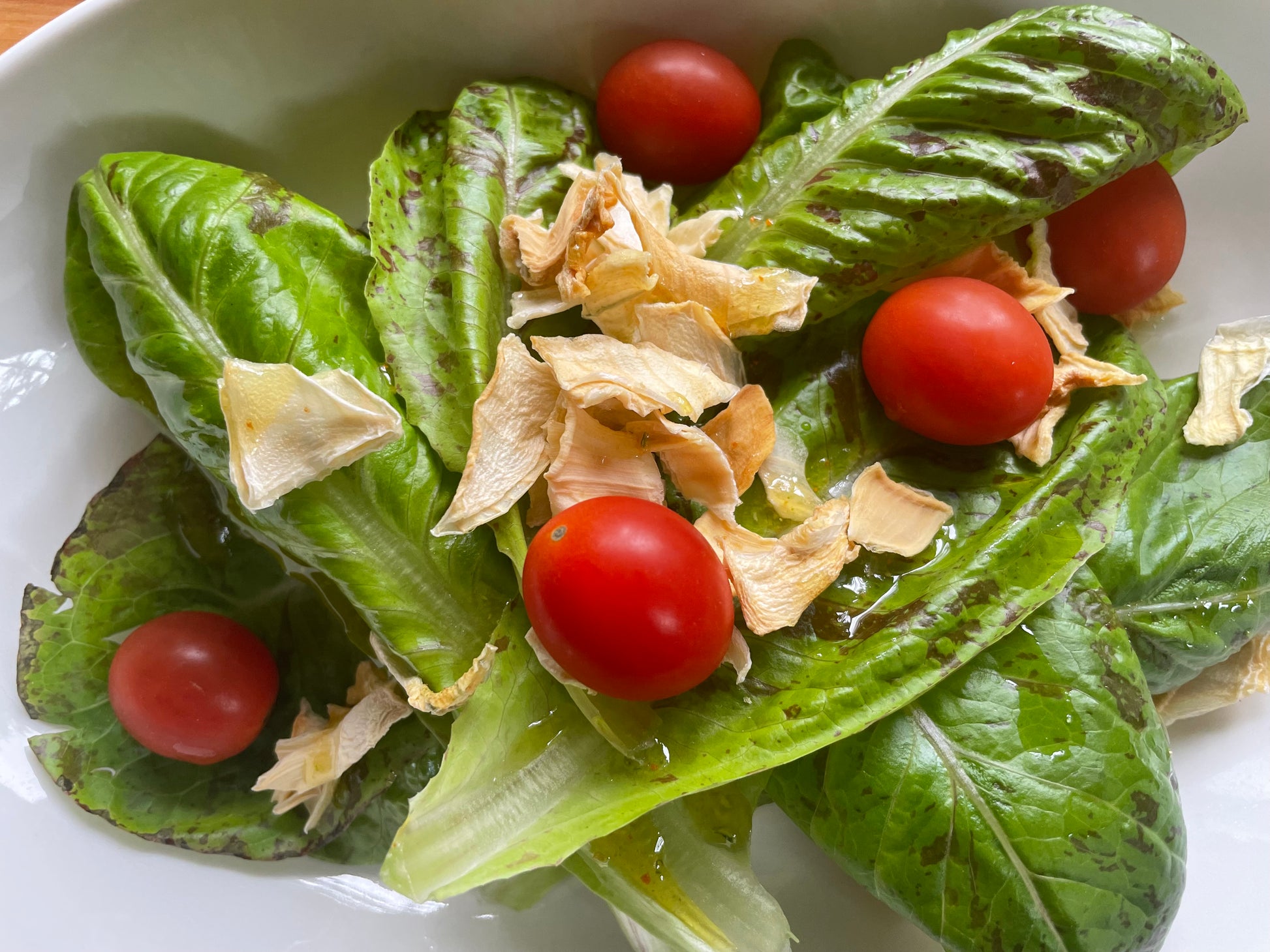 Salad with speckled leaf lettuce, dehydrated onions and tomatoes